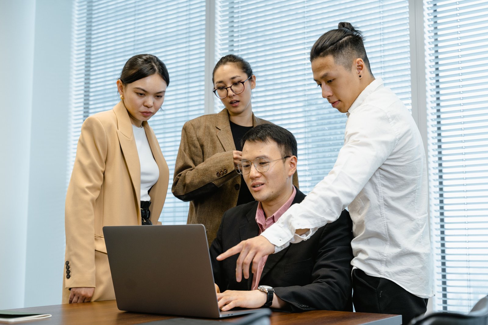 Team prüft gemeinsam eine Anwendung auf einem Laptop